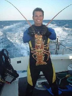 Eric O'Keefe holding a spiny lobster on a Key West dive boat